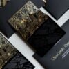Luxury black and gold wedding invitation suite featuring custom Atlanta skyline artwork, gold foil Art Deco details, glossy black acrylic-inspired accents, and layered editorial stationery