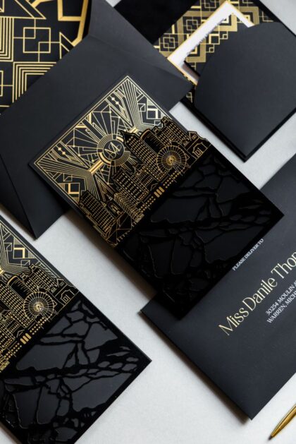 Luxury black and gold wedding invitation suite featuring custom Atlanta skyline artwork, gold foil Art Deco details, glossy black acrylic-inspired accents, and layered editorial stationery