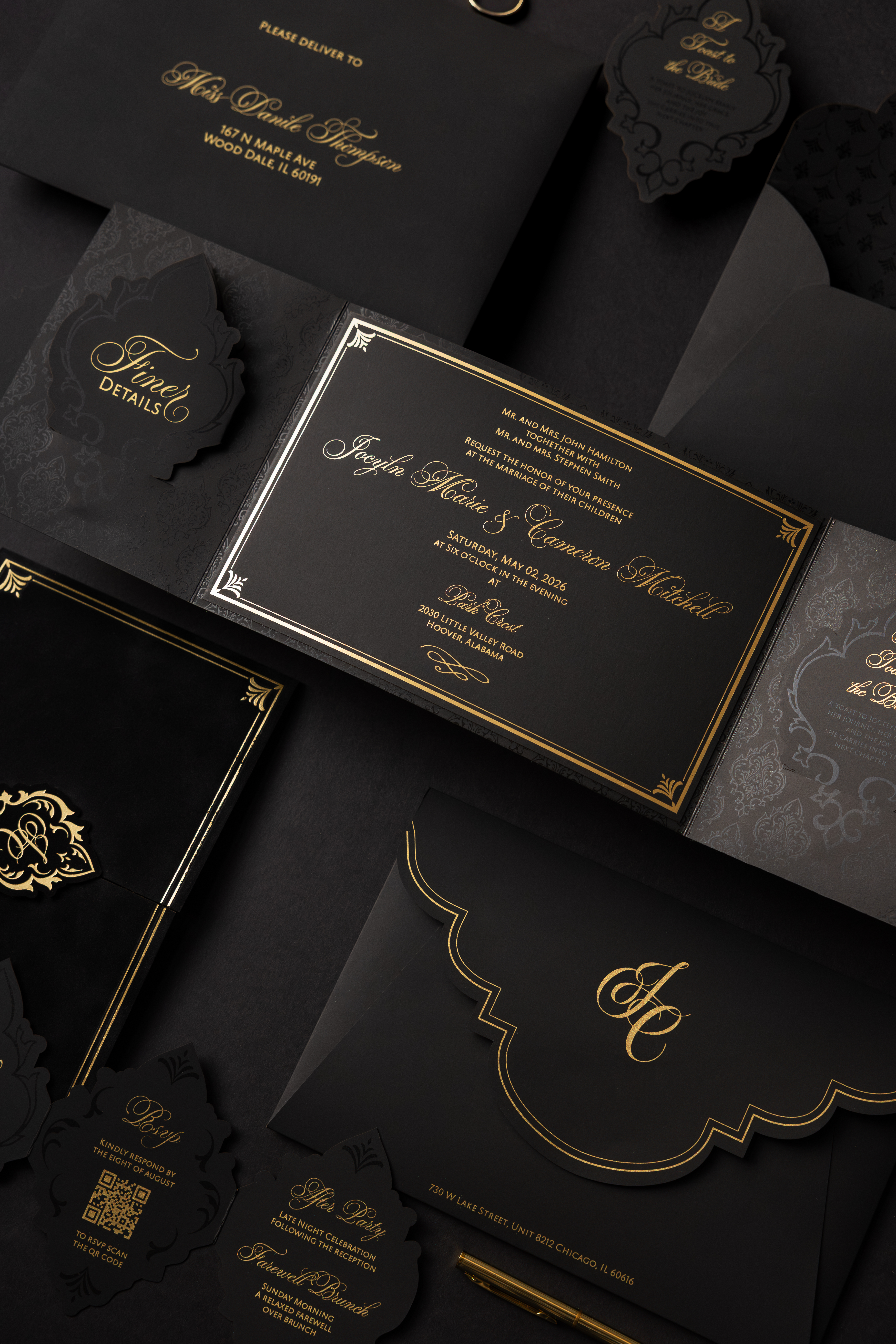 Luxurious black wedding invitation suite with ornate gold foil detailing, scalloped envelope design, elegant script typography, and coordinating RSVP and details cards styled on a dark moody background.