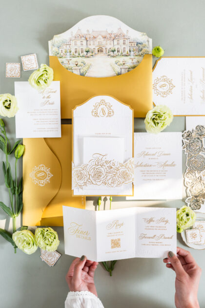 Luxury wedding invitation suite with embossed floral details, custom venue illustration, ornate monogram, layered inserts, and elegant gold foil accents designed by Sherry Green Designs for planners and sophisticated wedding celebrations
