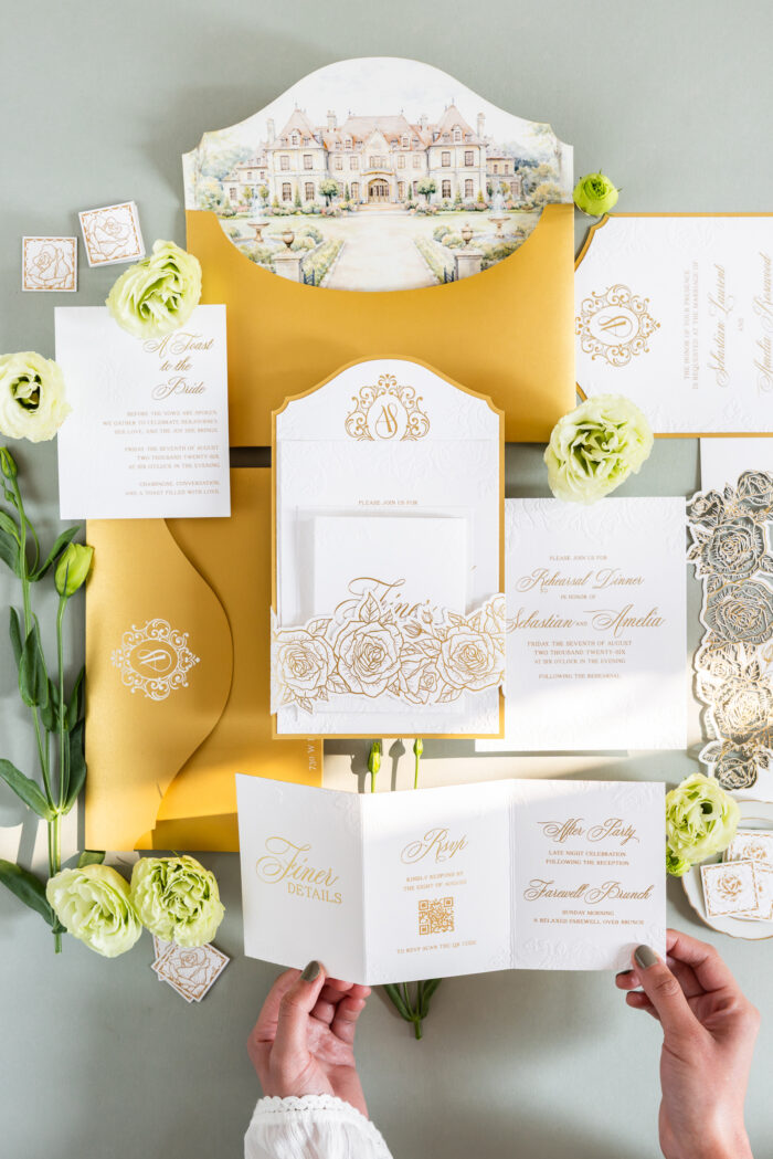 Luxury wedding invitation suite with embossed floral details, custom venue illustration, ornate monogram, layered inserts, and elegant gold foil accents designed by Sherry Green Designs for planners and sophisticated wedding celebrations