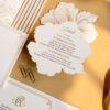 Luxury wedding invitation suite featuring gold foil details, floral-shaped accommodations card, layered inserts, and elegant black-tie wedding stationery styled with silk ribbon and refined editorial details