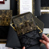 Luxury black and gold wedding invitation suite featuring gold foil Art Deco details, custom Atlanta skyline illustration, layered inserts, and glossy acrylic-inspired accents