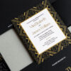 Luxury black and gold Atlanta rehearsal dinner invitation featuring gold foil Art Deco geometric patterns, layered black envelopes, and elegant editorial-style wedding stationery