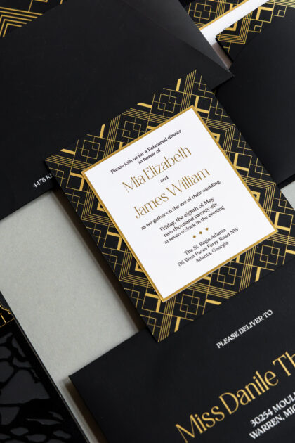 Luxury black and gold Atlanta rehearsal dinner invitation featuring gold foil Art Deco geometric patterns, layered black envelopes, and elegant editorial-style wedding stationery