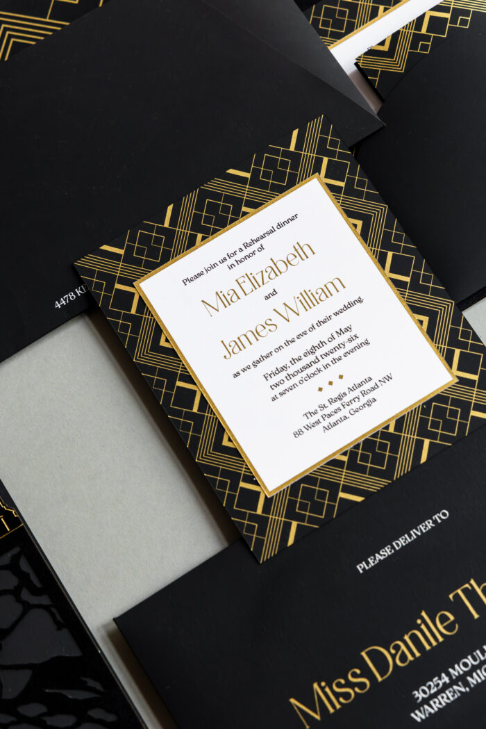 Luxury black and gold Atlanta rehearsal dinner invitation featuring gold foil Art Deco geometric patterns, layered black envelopes, and elegant editorial-style wedding stationery