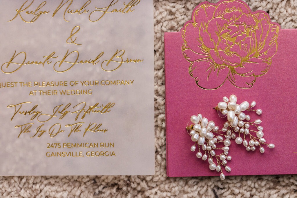 Close-up of vellum wedding invitation with gold foil calligraphy and pink floral card detail by Inked Green Designs