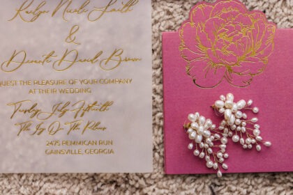 Close-up of vellum wedding invitation with gold foil calligraphy and pink floral card detail by Sherry Designs