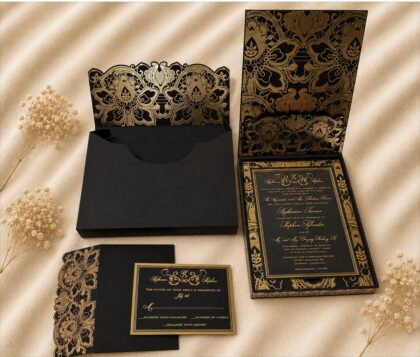 Luxury black and gold wedding invitation suite featuring an ornate floral presentation box, gold foil invitation, lace-inspired pocket, and coordinating RSVP card.