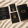 Luxury black and gold wedding stationery featuring a custom invitation box, elegant menu card, RSVP card, details card, and gold foil accents styled on a soft ivory fabric backdrop.